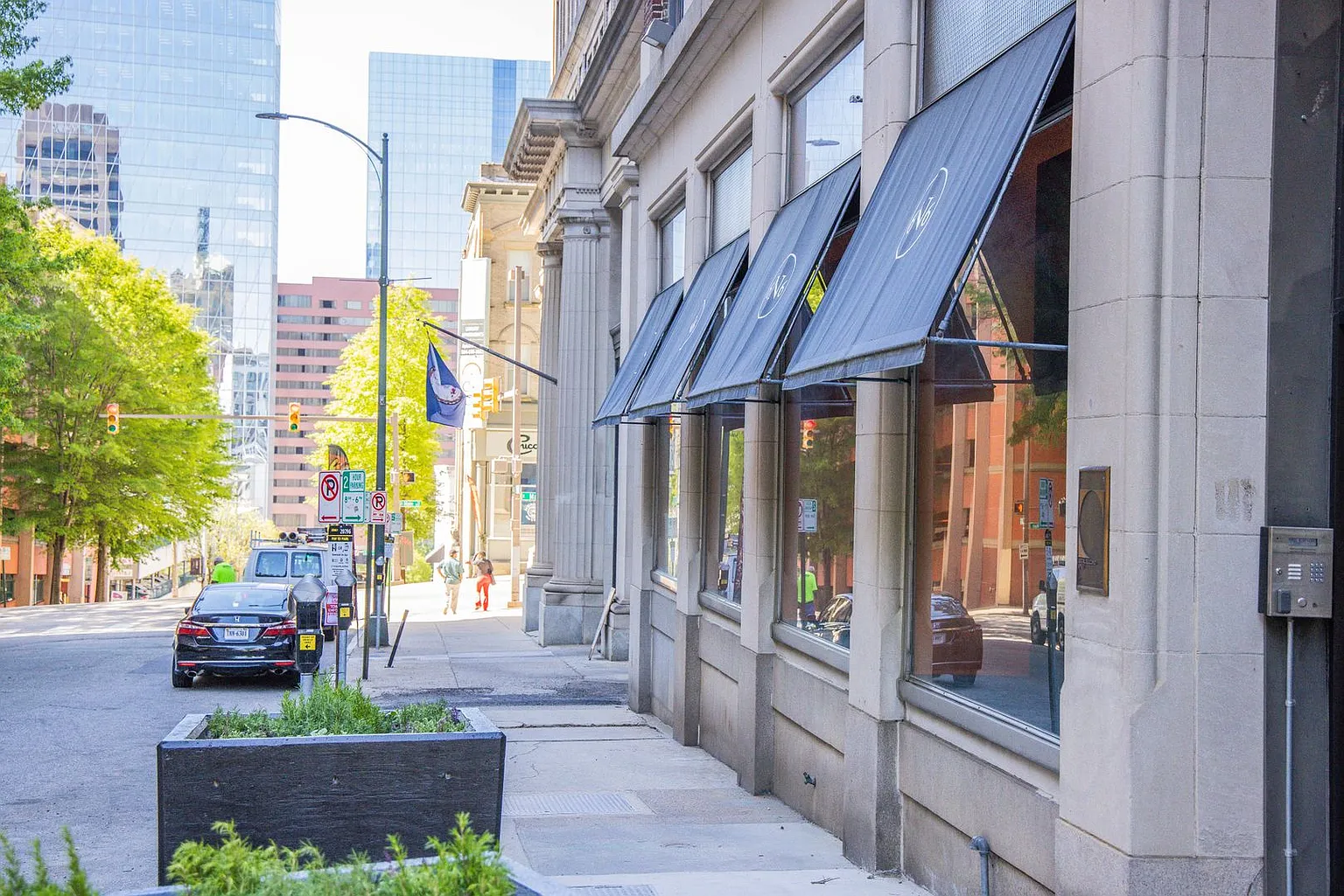 6 North 6th Street street-level view, with the building's awnings, stone columns, and downtown Richmond sidewalk
